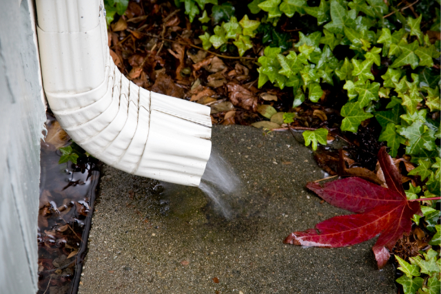 Bend Rain Gutter System with water flowing out of the downspout